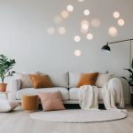 A serene, minimalist room with soft lighting, plants, cushions, and calming decor