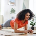 woman in a red tshirt planking during a home workout